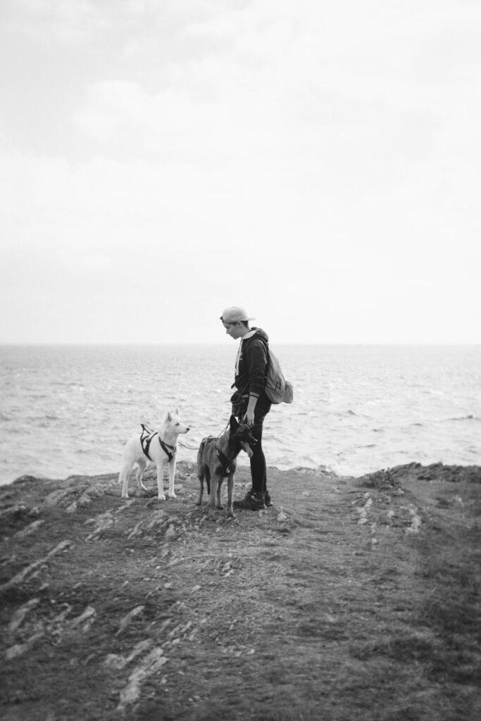 Andréa avec ses deux chiennes, Alkyra le husky et Jelfy le berger belge malinois lors d'une randonnée en bord de mer